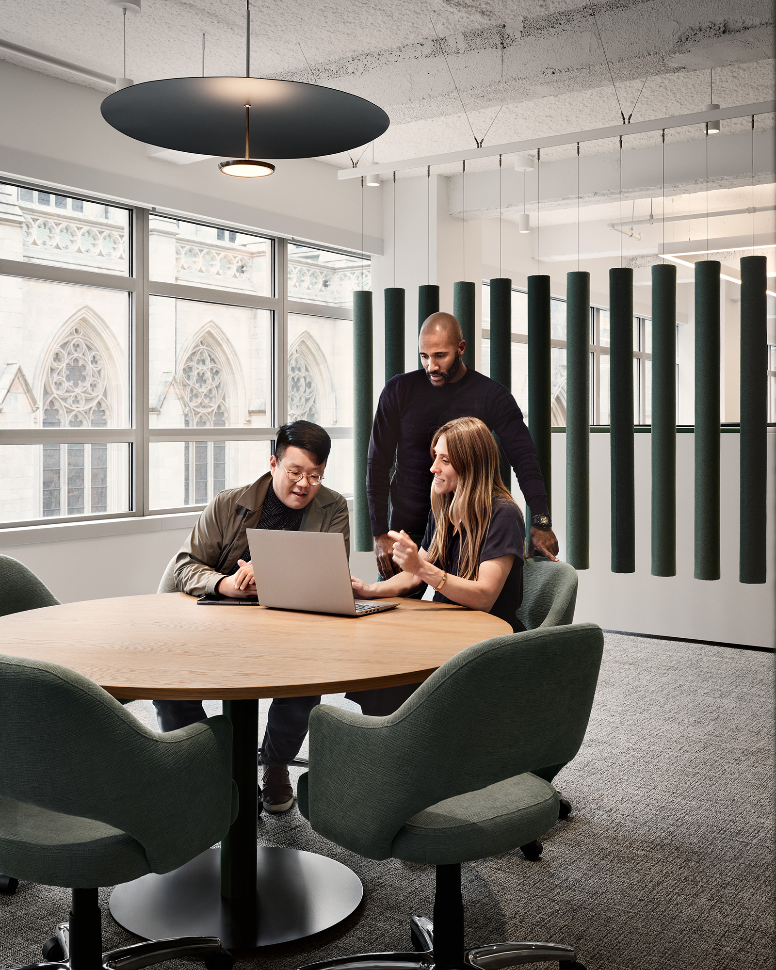 A group of people sitting at a table with a laptop.