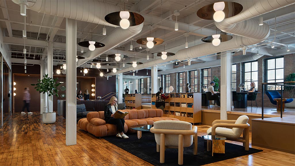 A person sitting on a couch in a large room with a large glass ceiling.
