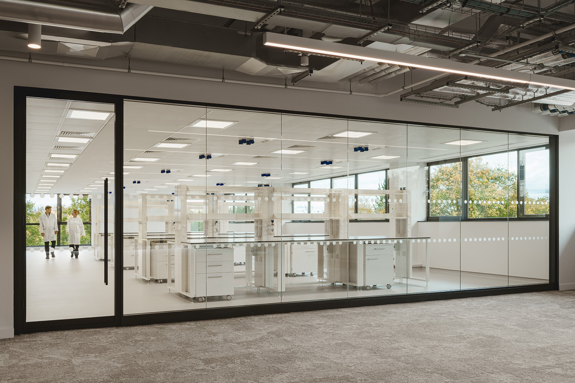 A large white room with a few people in it.