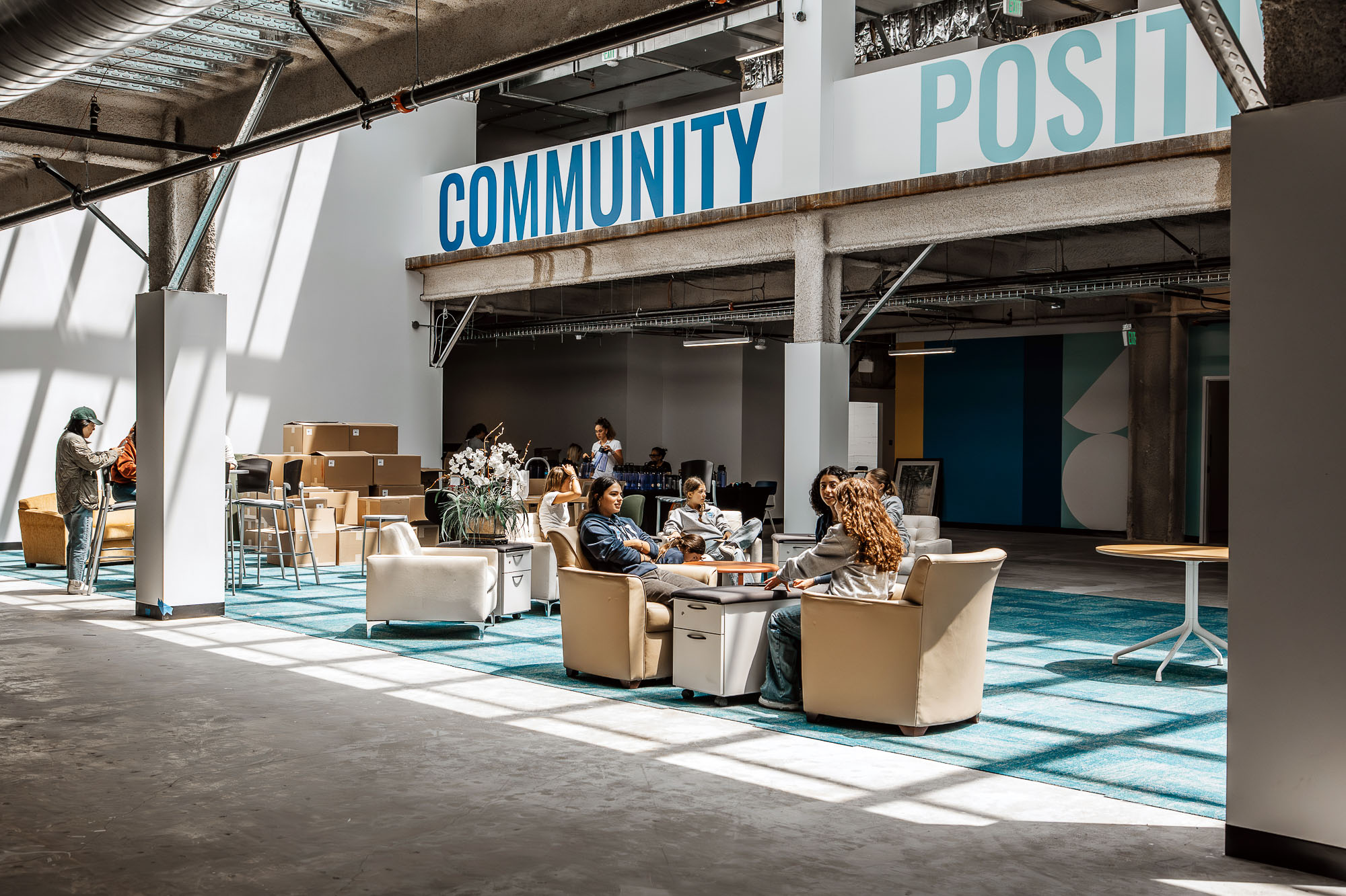 A group of people sitting in a room with a sign.