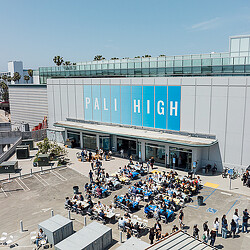 A large building with a large group of people outside.