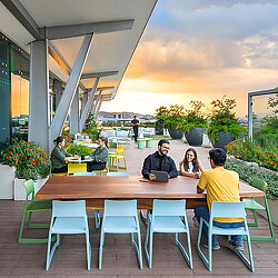 A group of people sitting at a table outside.