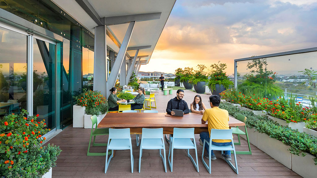 A group of people sitting around a table outside.