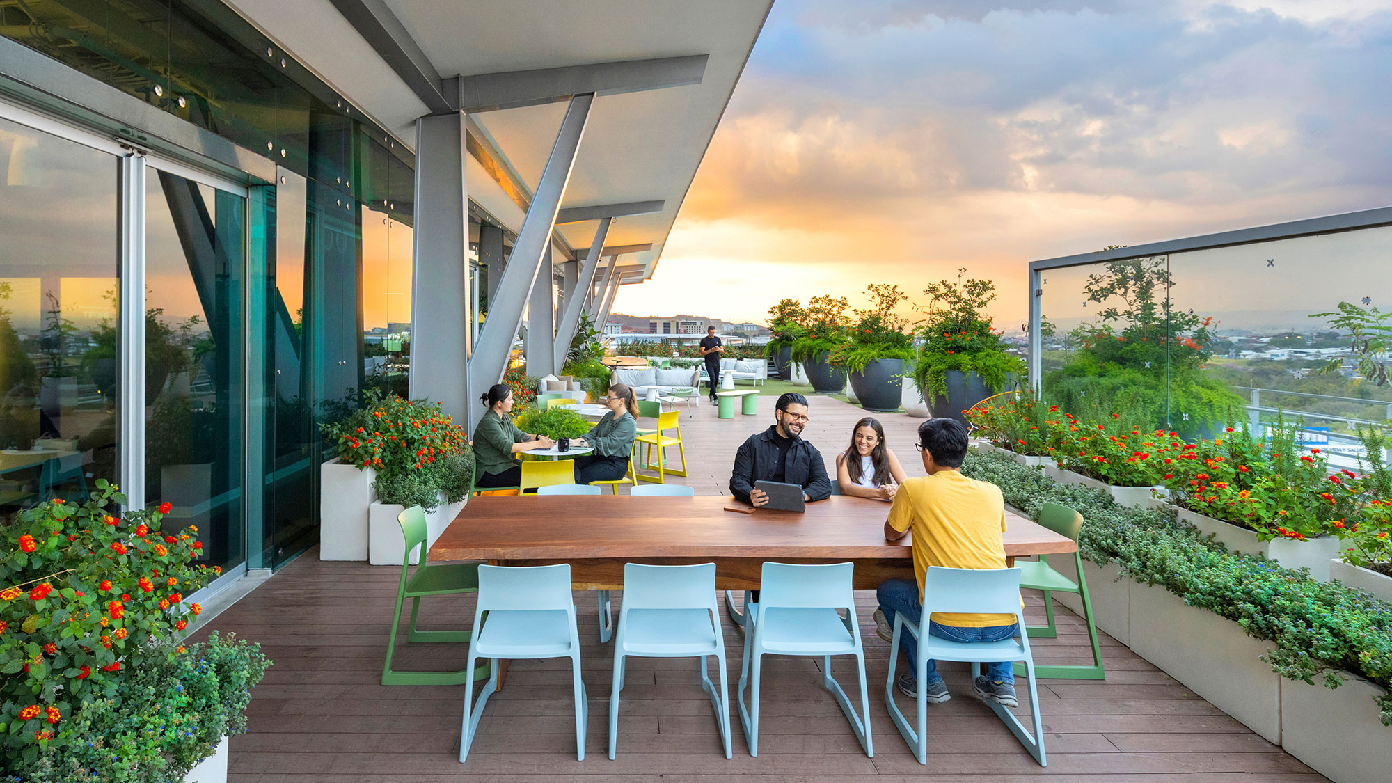 A group of people sitting around a table outside.