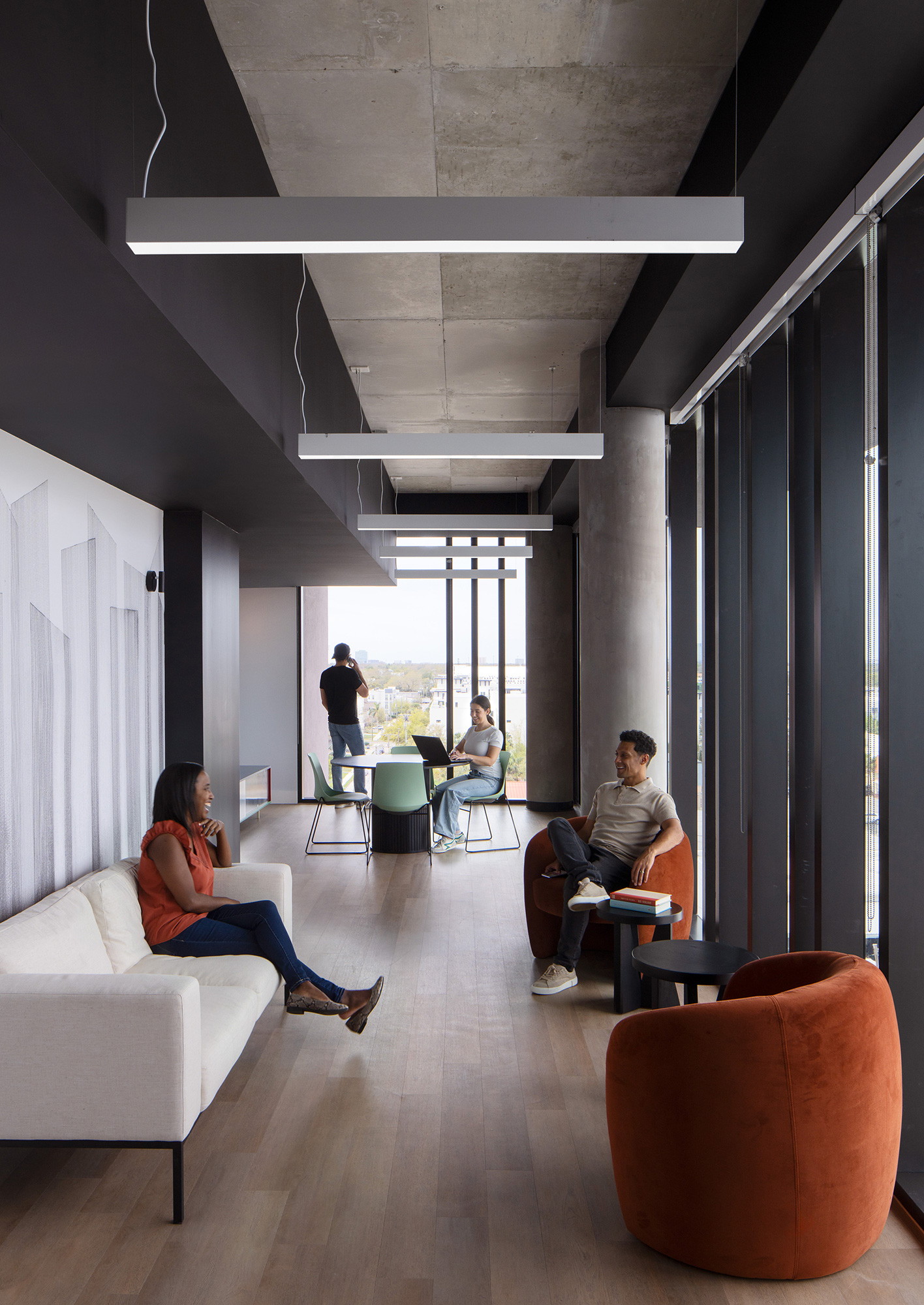A group of people sitting in a room with a large window.
