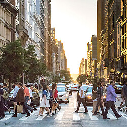 A group of people walking on a street in a city.