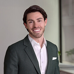 A man in a suit smiling.