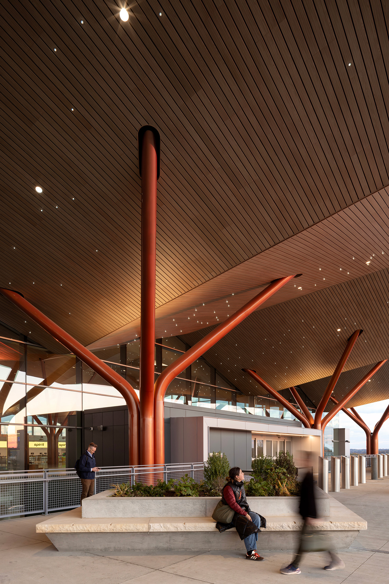A group of people walking under a roof.