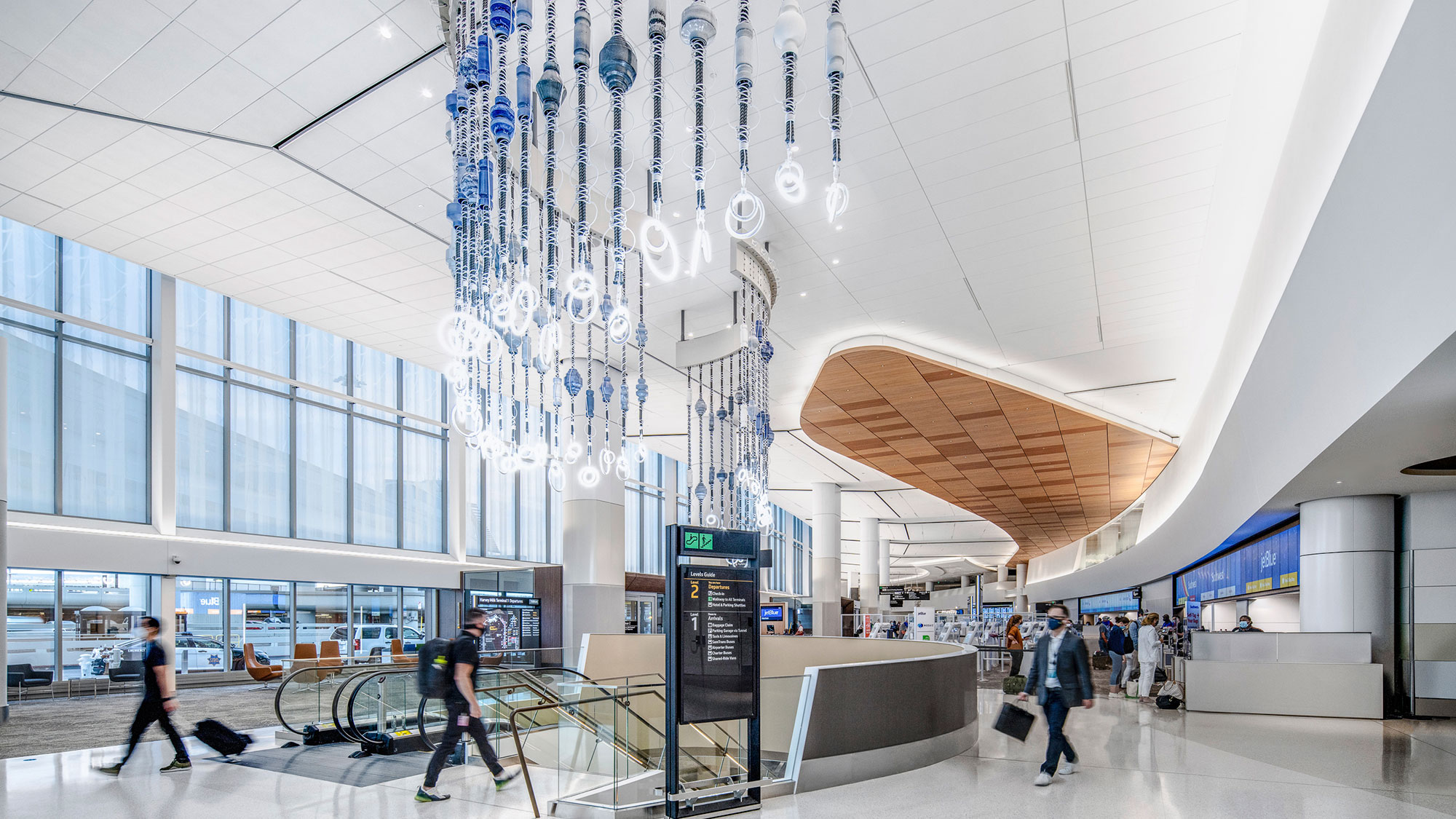 A large room with people and a large glass ceiling with many lights.