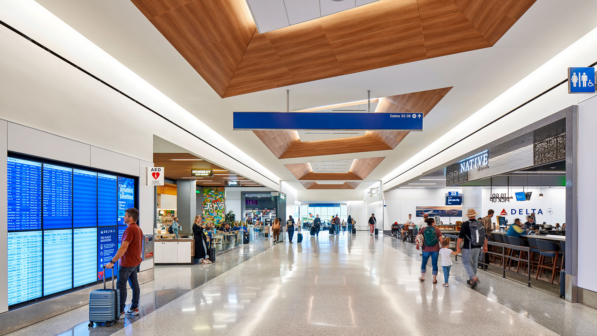 People with luggage in a large building.