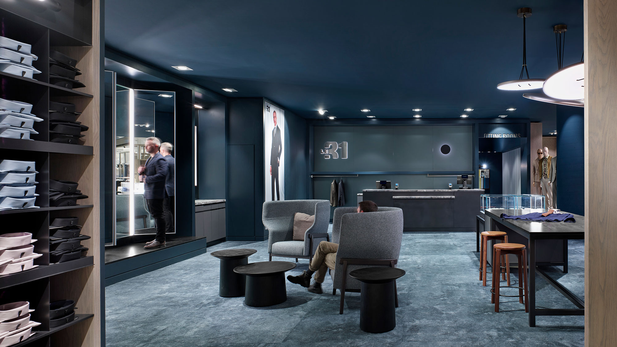 A person standing in a room with a chair and a table.