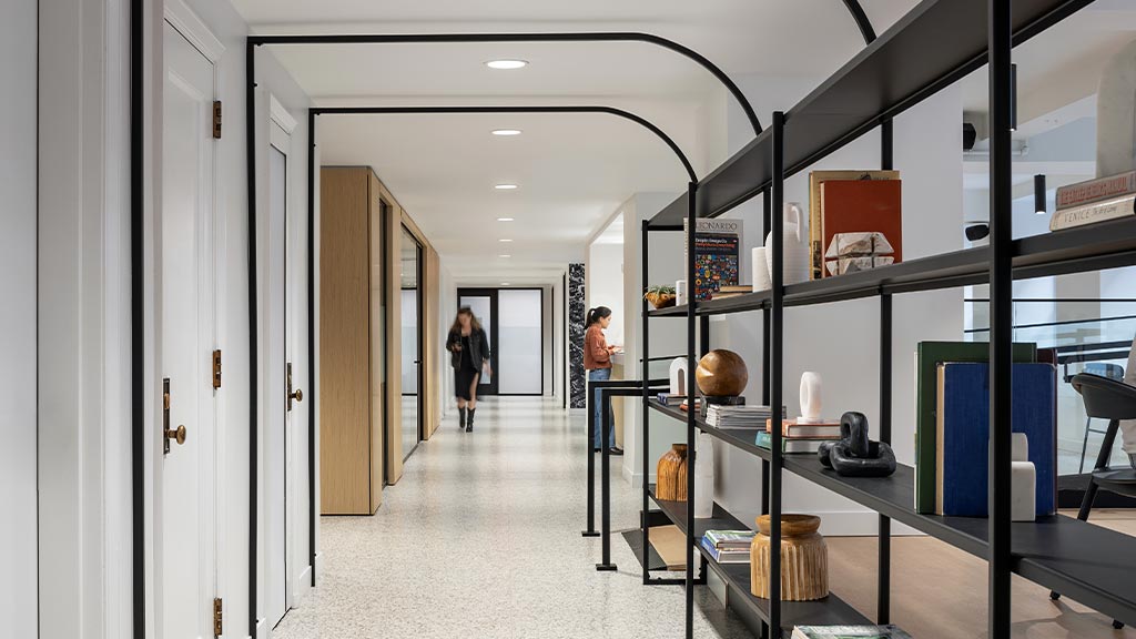 A couple of women walking through a hallway.
