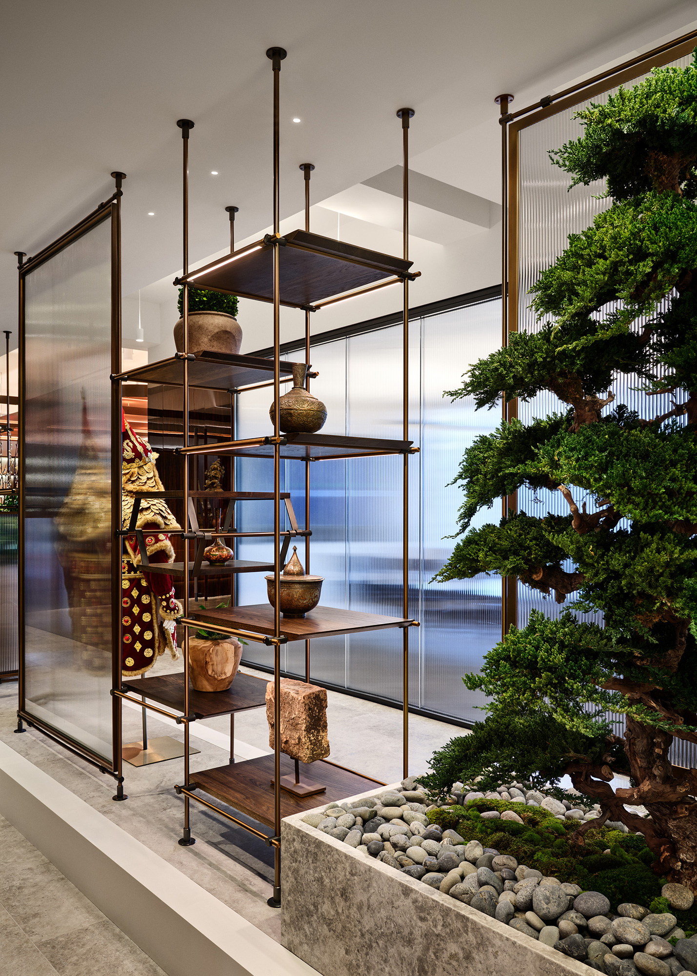 A glass display case with a tree and a table with a candle.
