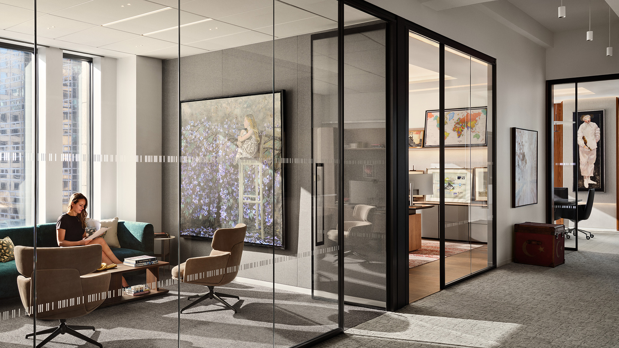 A person sitting on a couch in a room with glass walls.