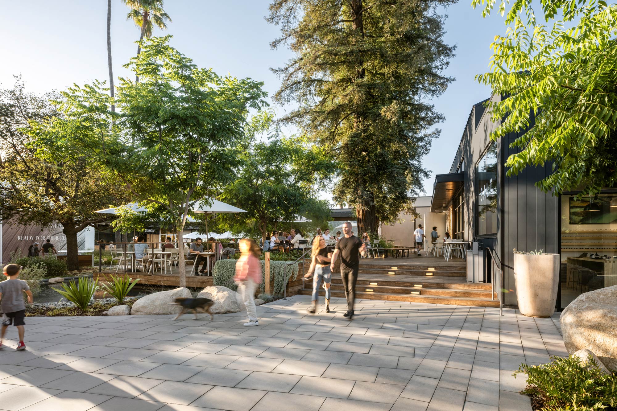A group of people walking on a brick walkway.
