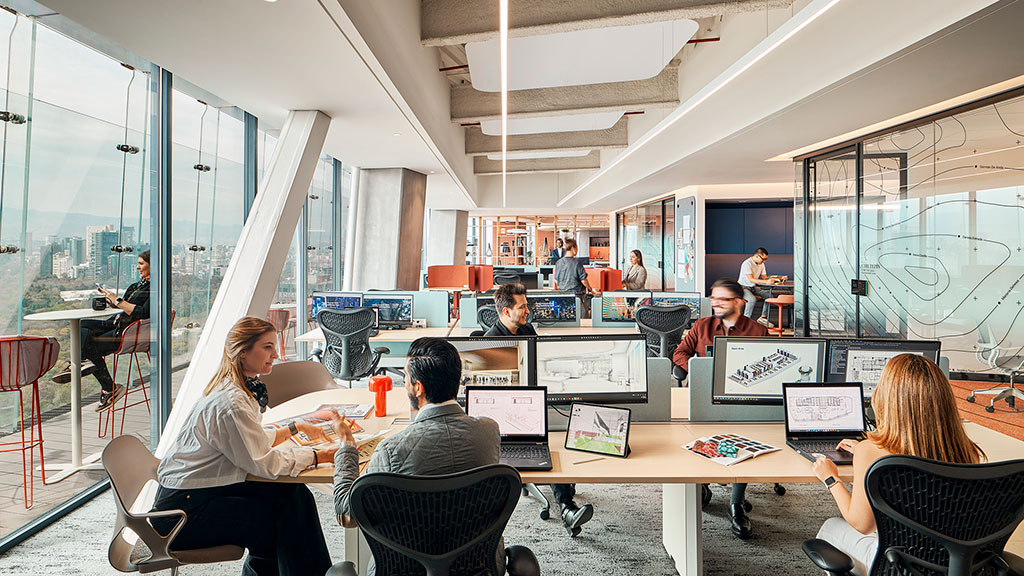 A group of people sitting around a table with computers.