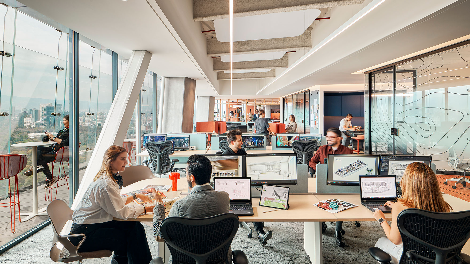 A group of people sitting around a table with computers.