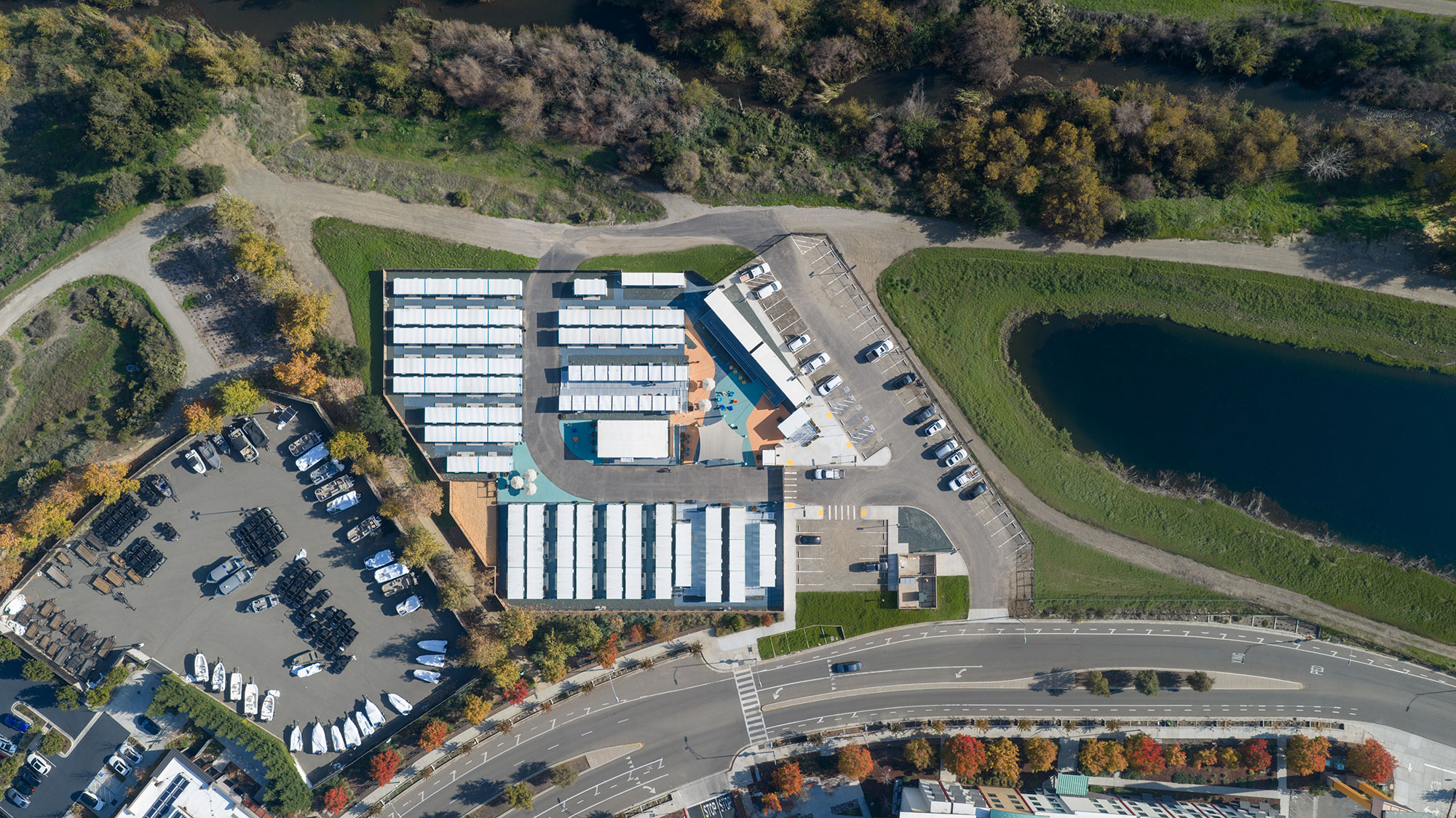 A building with a parking lot and a body of water in the background.