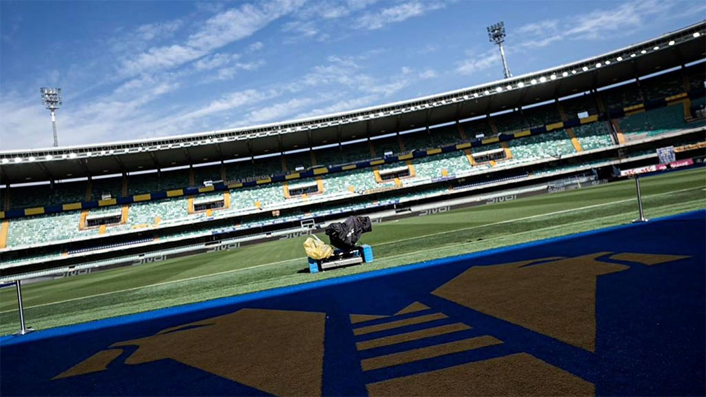 A sports stadium with a person sitting on a bench.
