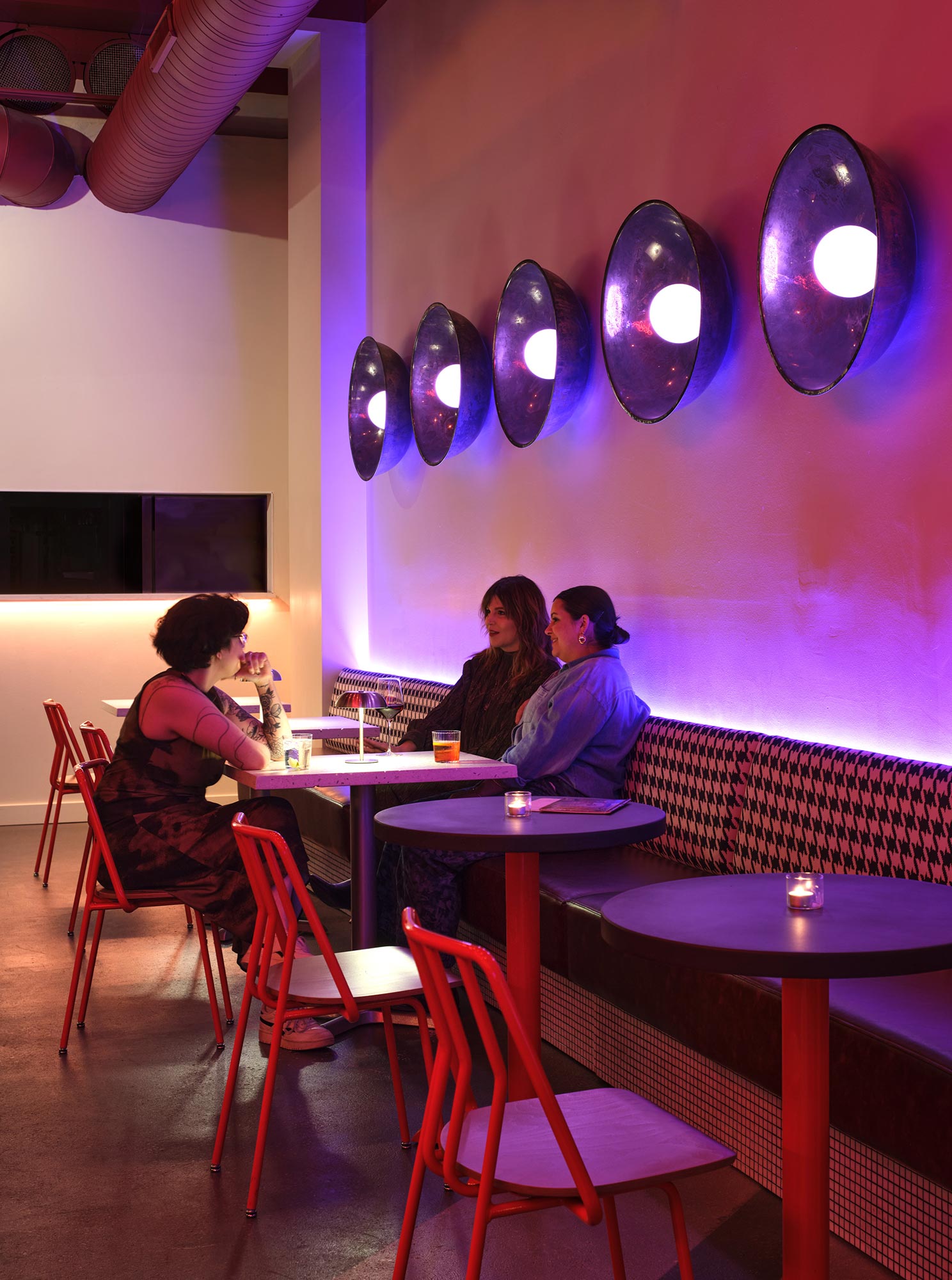A group of people sitting at a table with balloons above them.