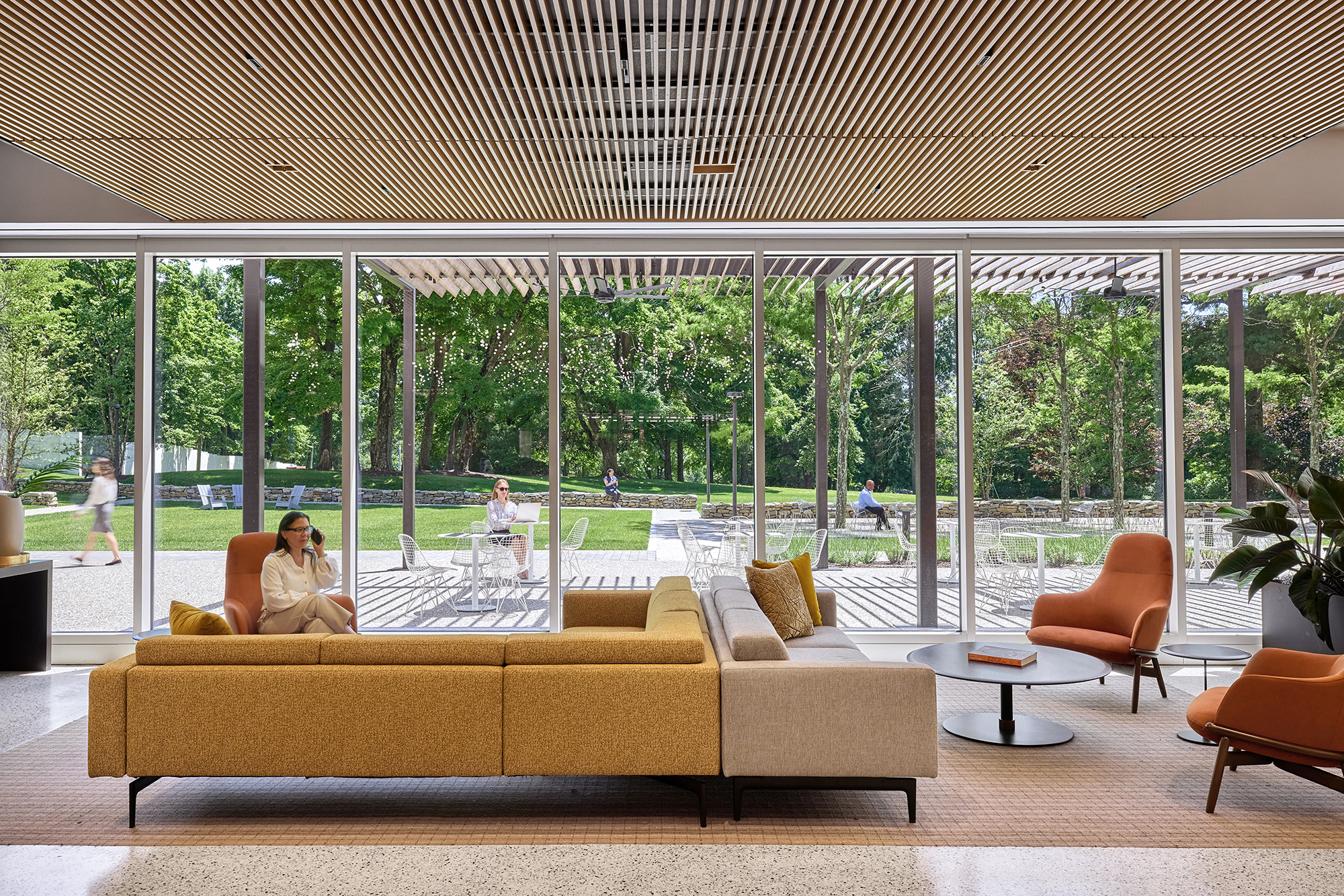 A person sitting on a couch in a room with glass walls.