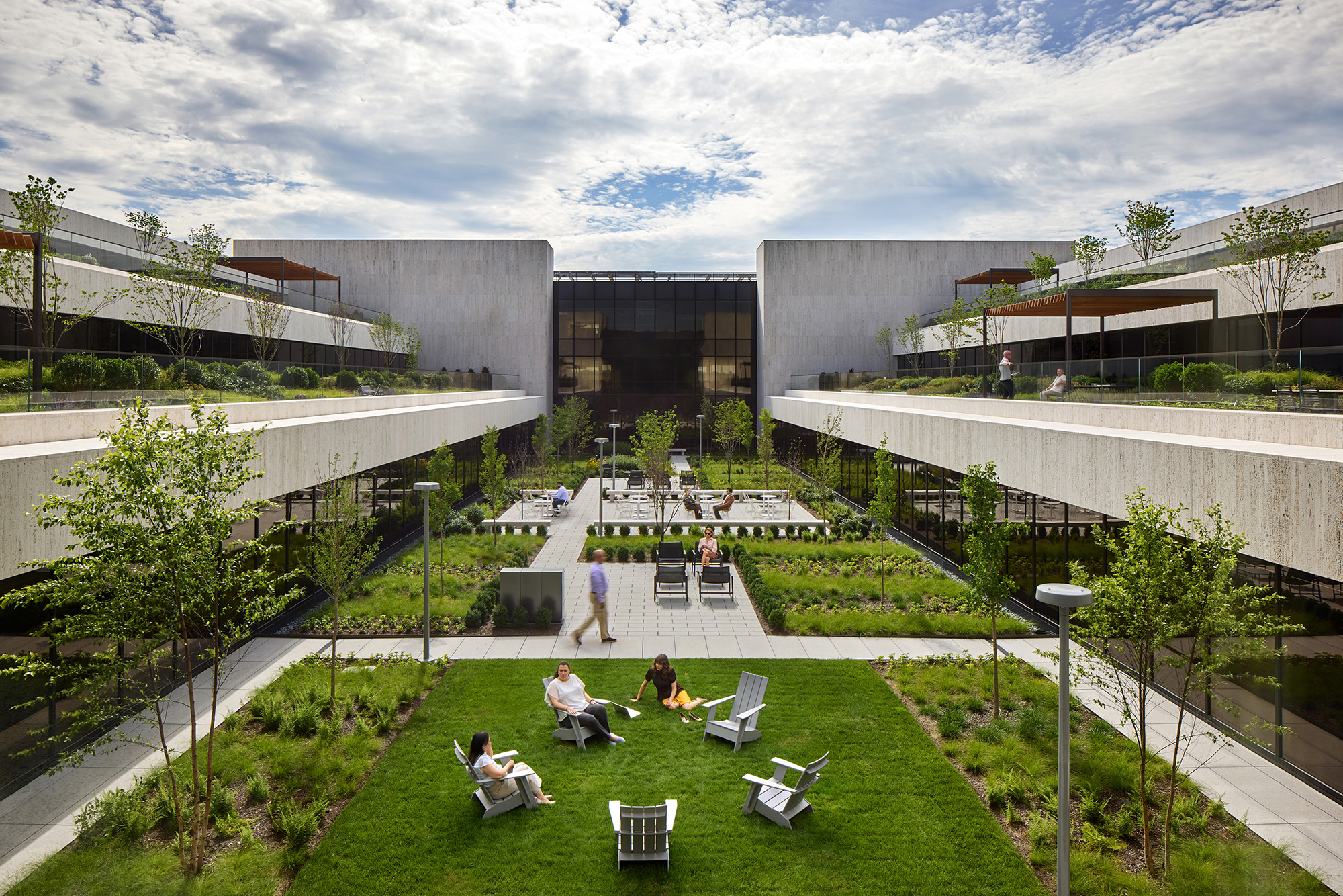 A group of people sitting on chairs in a courtyard.