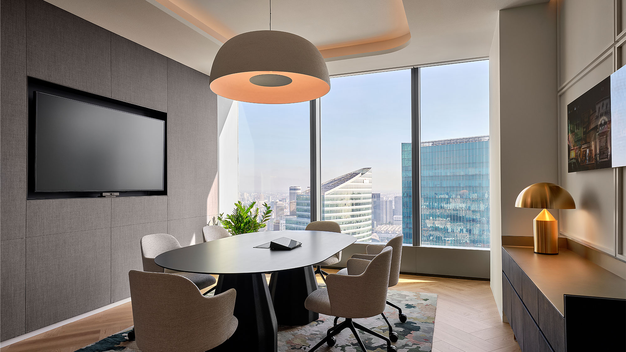 A room with a table and chairs and a tv on the wall.