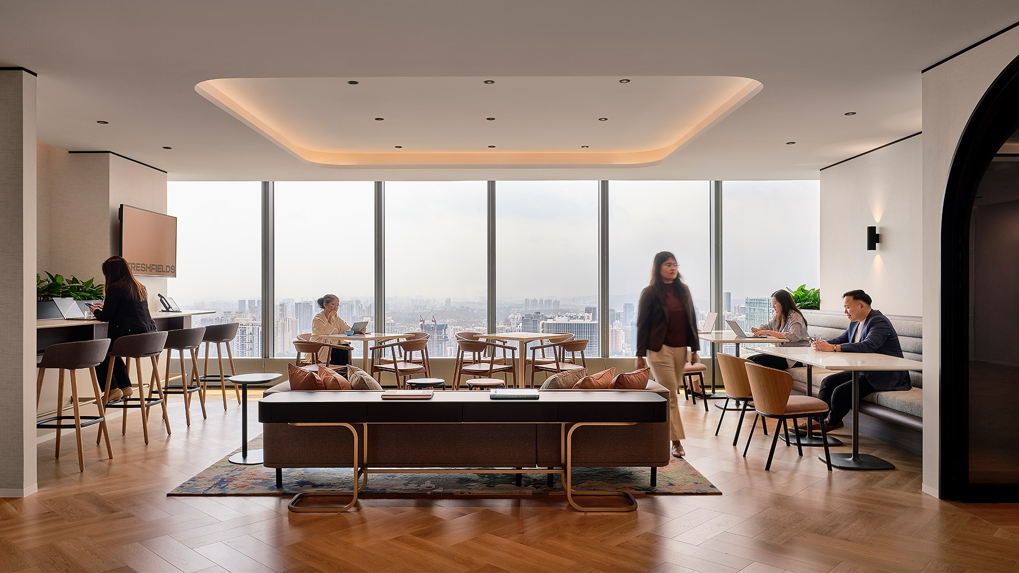 A group of people in a room with large windows.