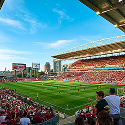A football stadium with a field and players on the field.
