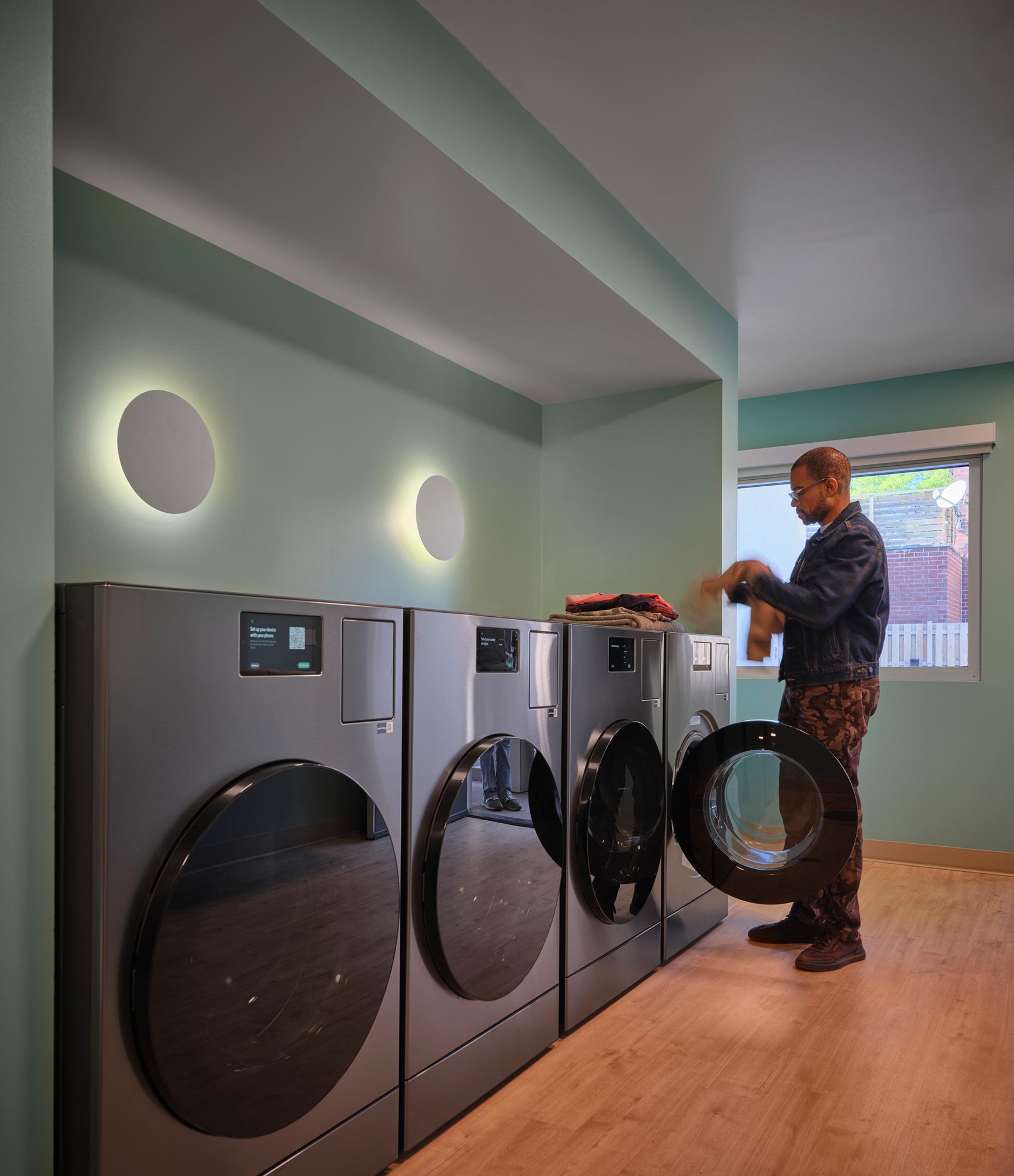 A man standing next to a washing machine.