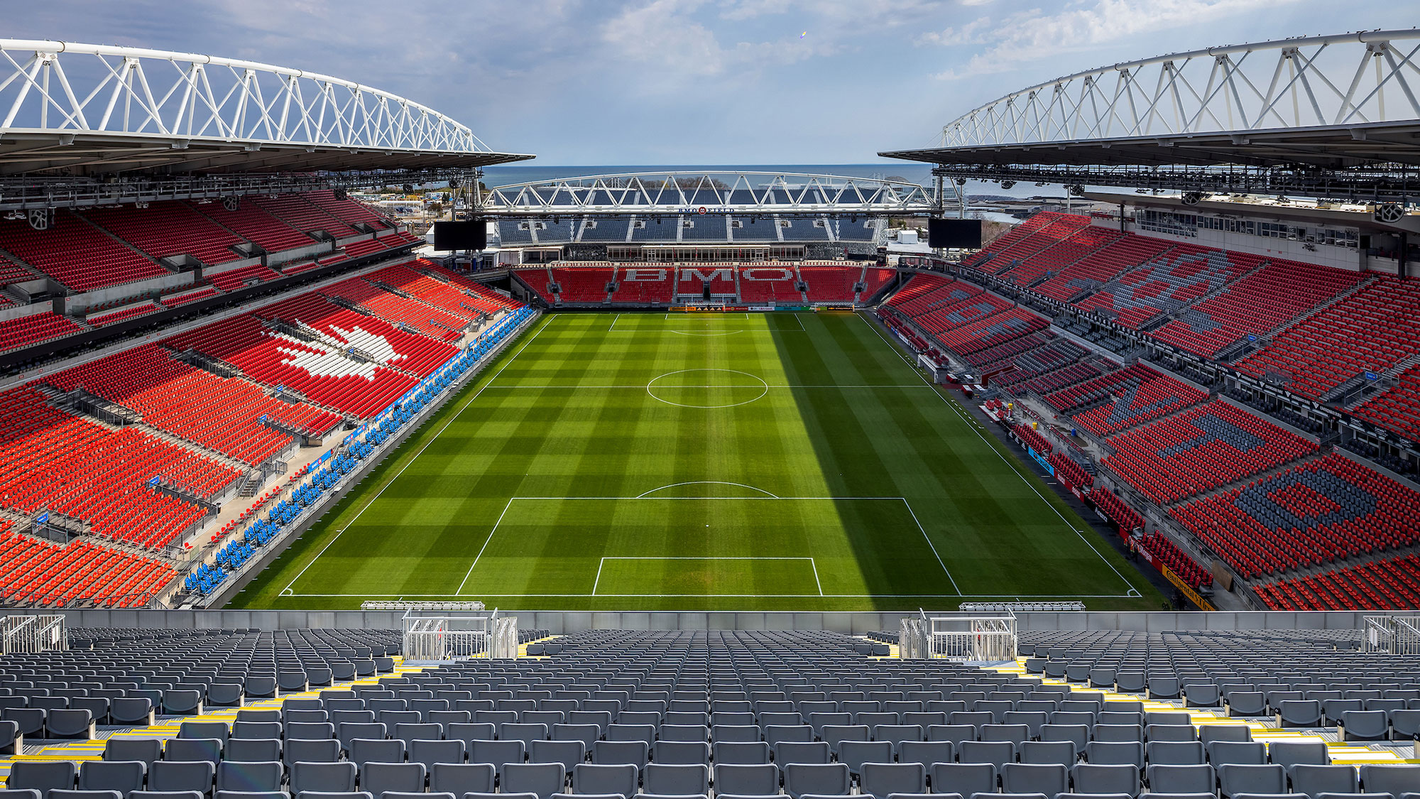 A sports stadium with a green field.