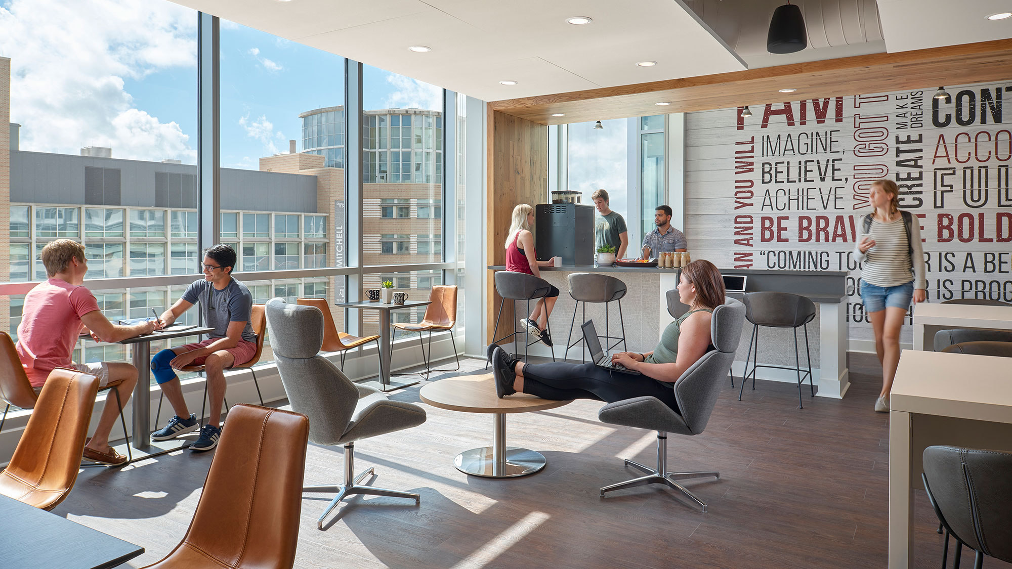 A group of people sitting around a table in a room with windows.