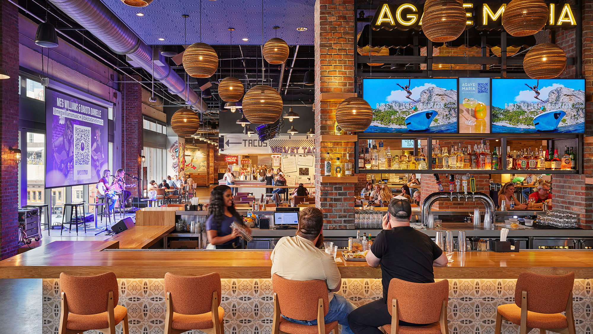 A group of people sitting at a bar.