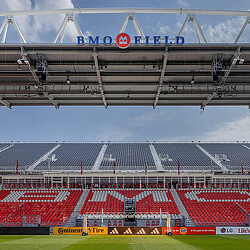 A sports stadium with a field and a large crowd.