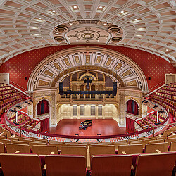 A large theater with red seats.