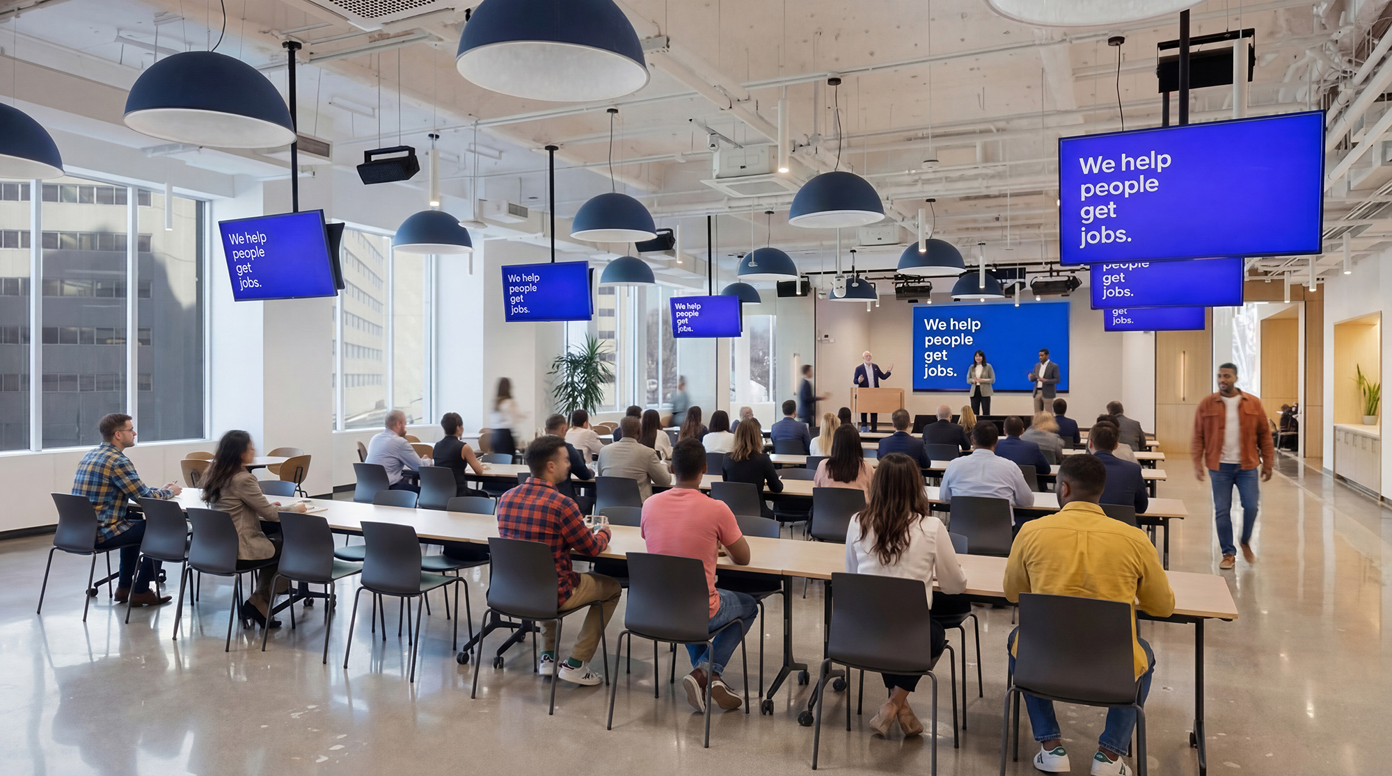 A group of people sitting in a room with a person standing in front of them.