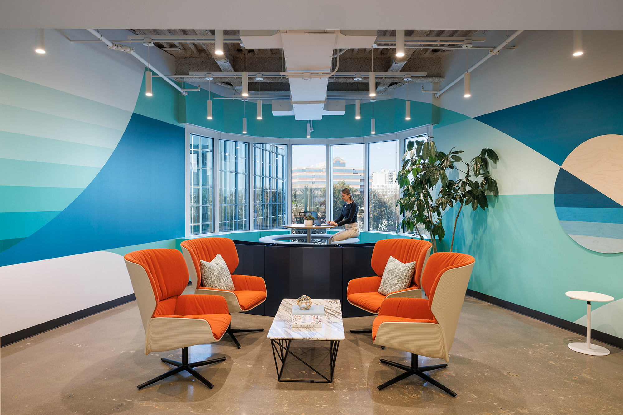 A room with a table chairs and a large window.