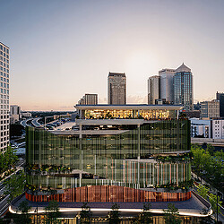 A large glass building with a city in the background.