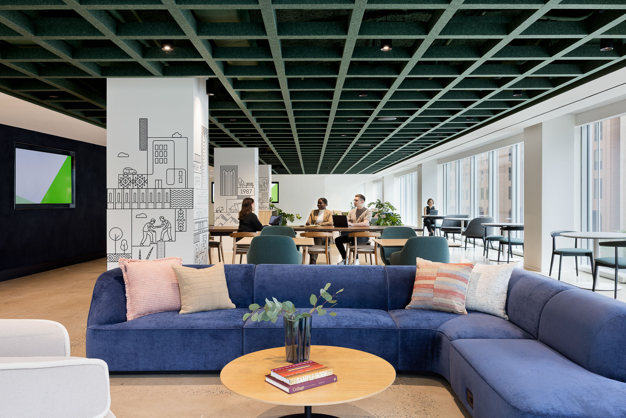 A room with blue couches and people in it.