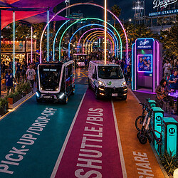A couple of buses on a street with people and bikes.