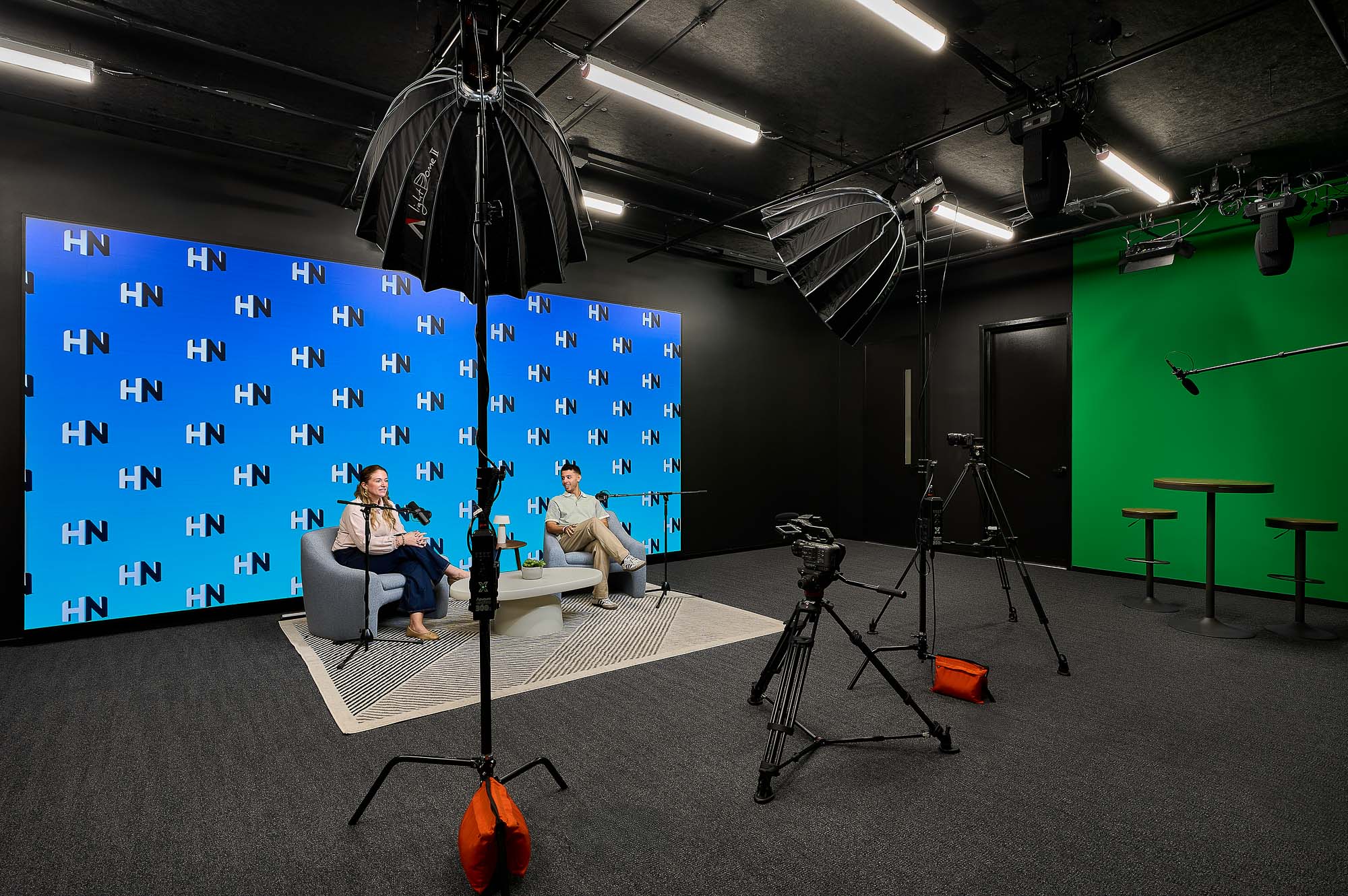 A couple of people sitting in chairs in front of a projector screen.