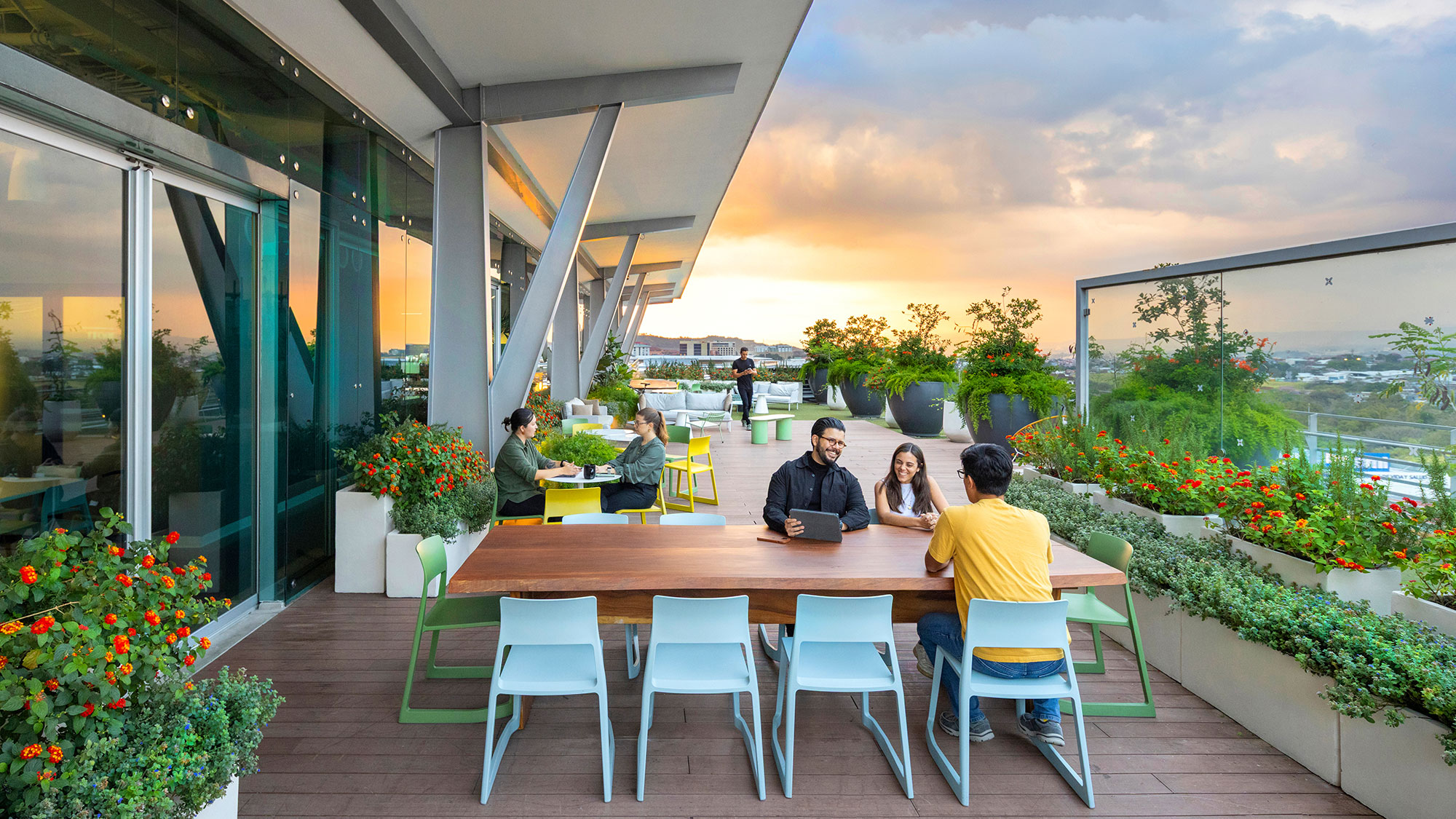 A group of people sitting around a table outside.