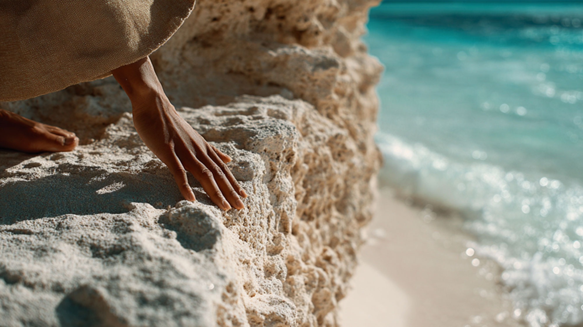 A person's hands on a beach.