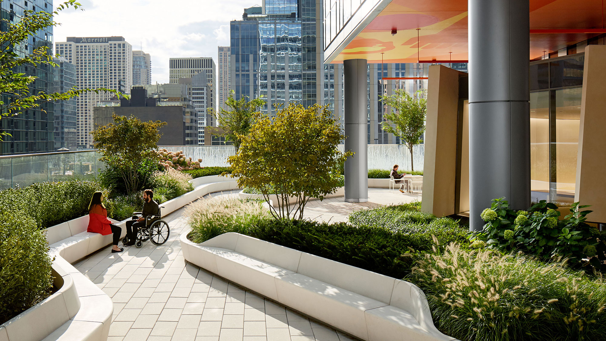 A man and woman sitting on a bench in a courtyard with a bike.