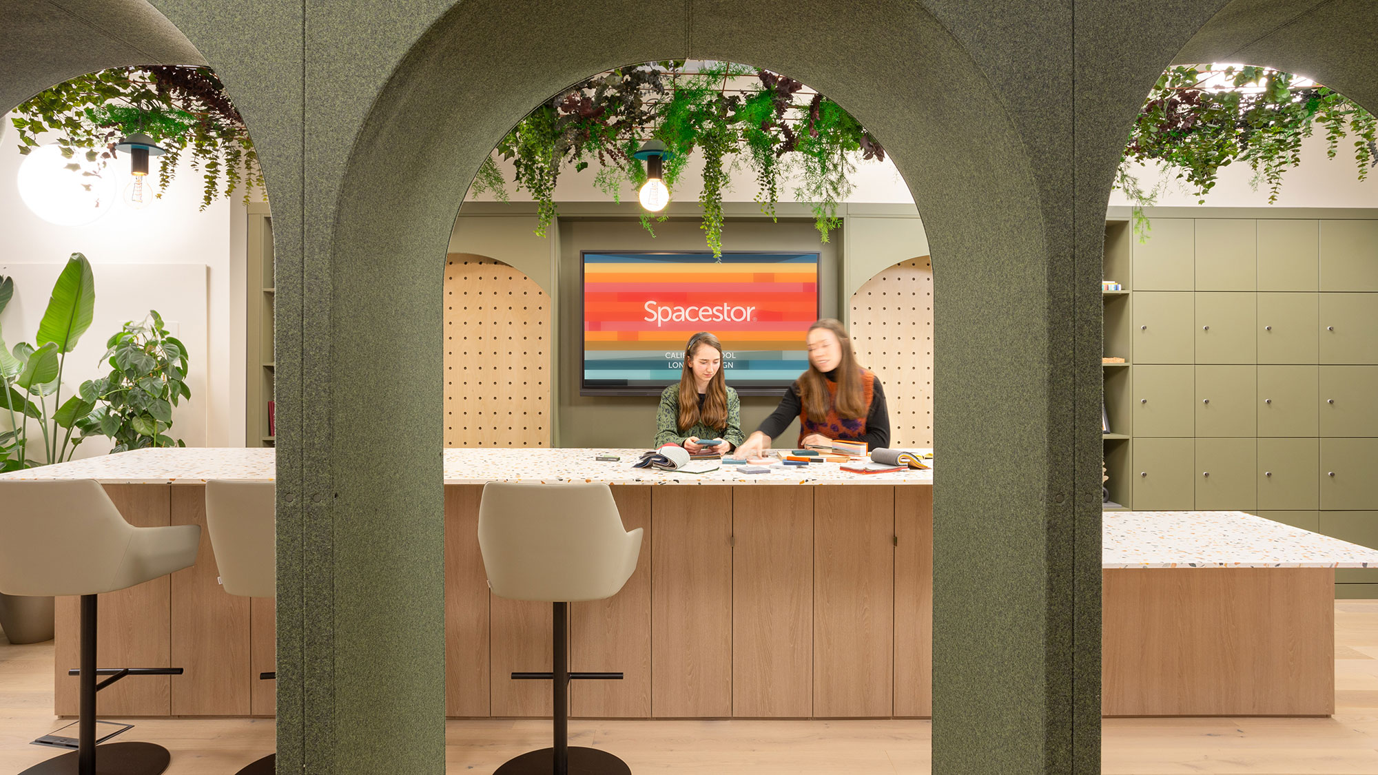A couple of women sitting at a table in a room with a large window.