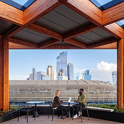 A man and woman sitting at a table with a view of a city.