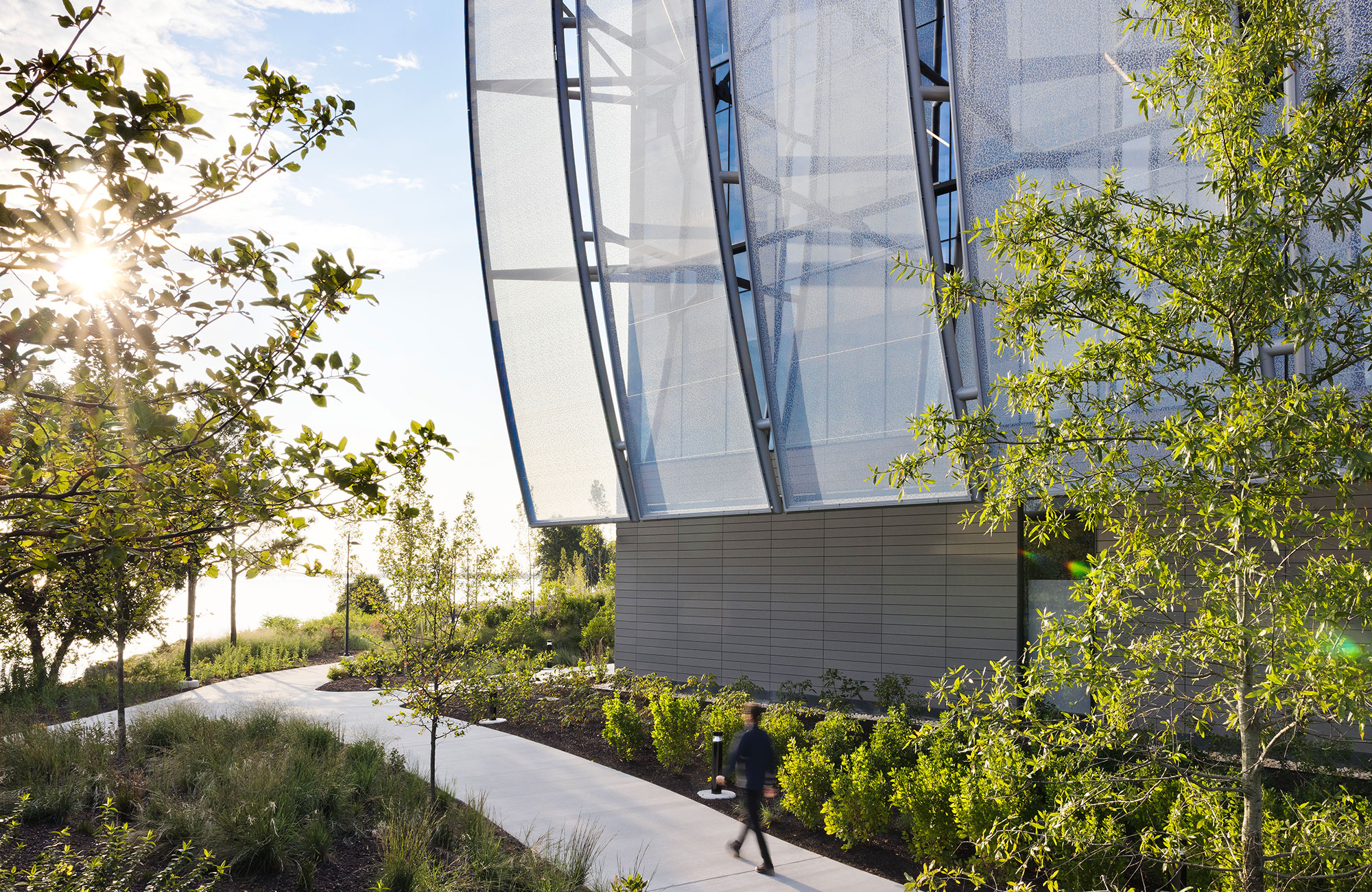 A person walking on a path next to a building.
