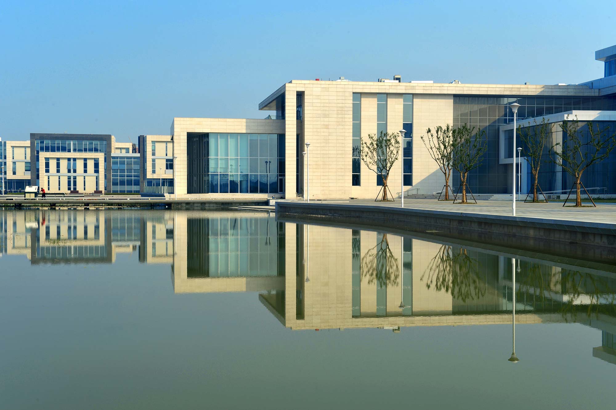 A building with a reflection of trees in the water.