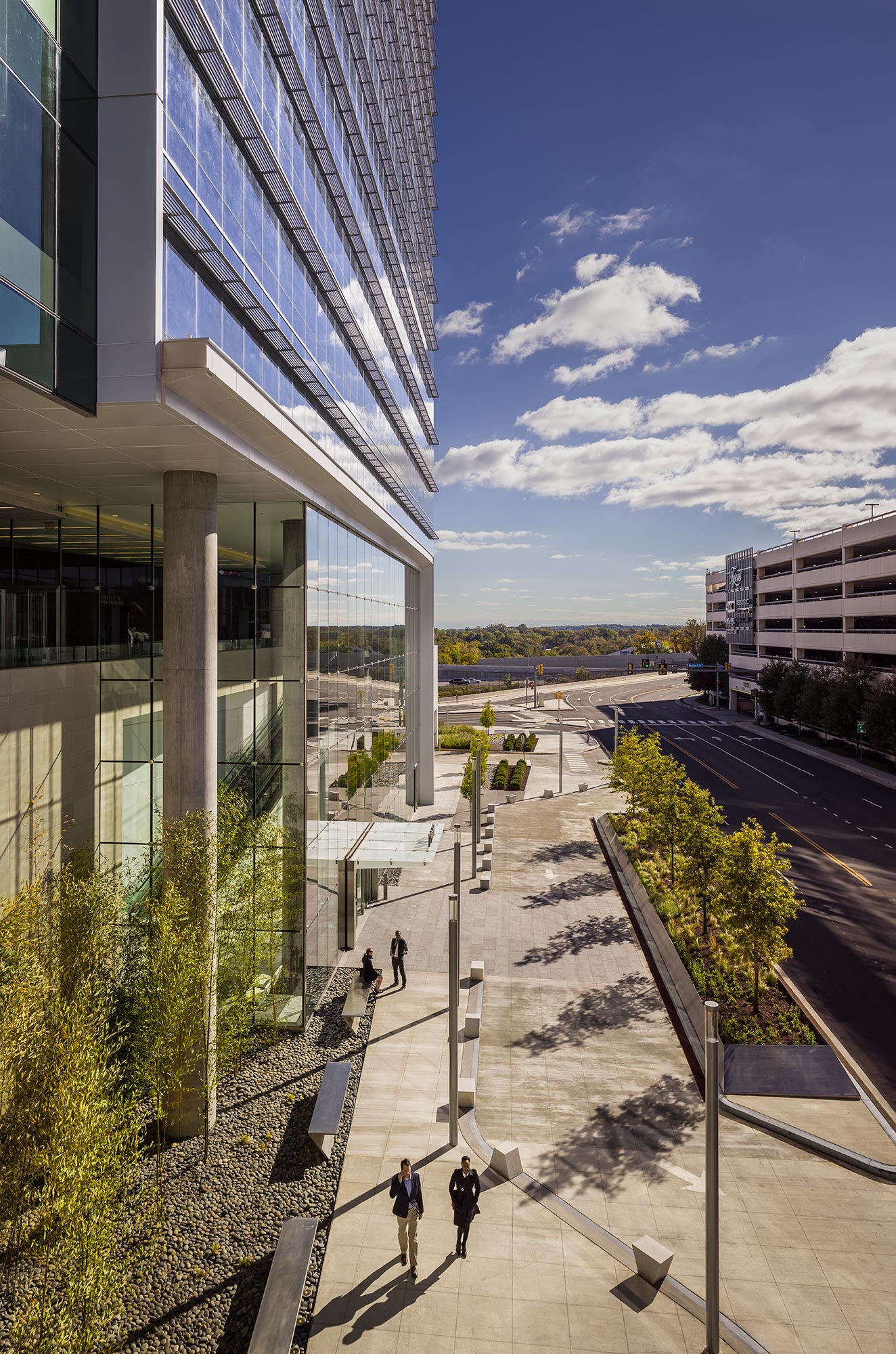 People walking on a walkway between buildings.