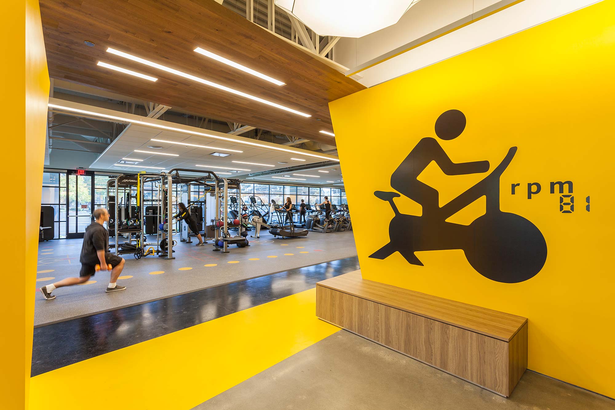 A person sitting on a bench in a gym.